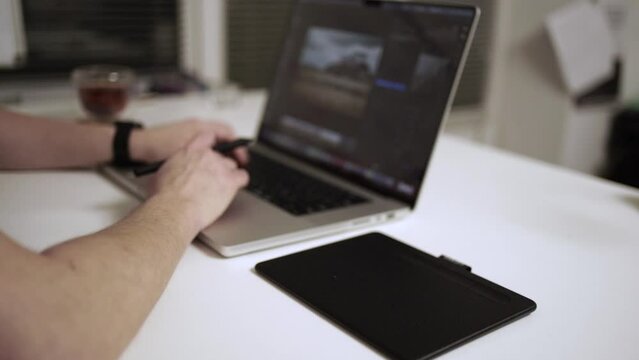 Photographer working on laptop on the table. Editing photograph