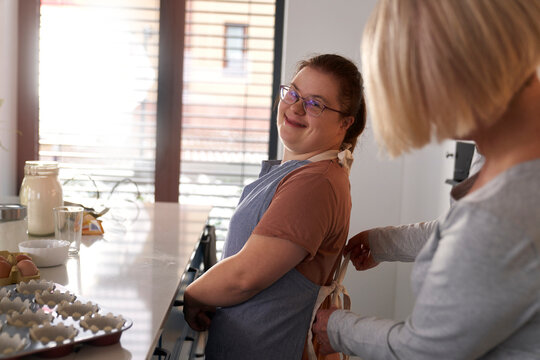 Down syndrome woman and her mother before baking together
