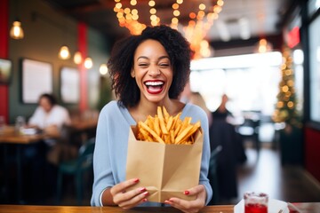 smiling person presenting a paper bag full of fries with a gift tag