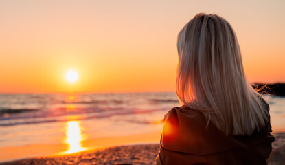 a woman watching a sunset on a torpical beach generated with artificial intelligence