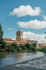Tower of a gothic church near the river on a summer day. Aguilar de Campoo, Spain