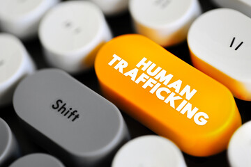 Human Trafficking is the trade of humans for the purpose of forced labour, text concept button on...