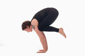 Bakasana, Ashtanga yoga  Side view of woman wearing sportswear doing Yoga exercise against white background.