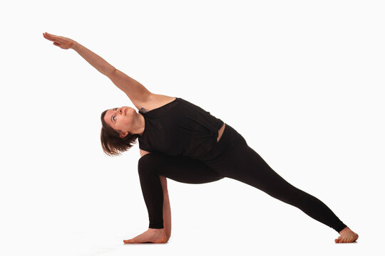Parsvakonasana, Ashtanga yoga  Side view of woman wearing sportswear doing Yoga exercise against white background.
