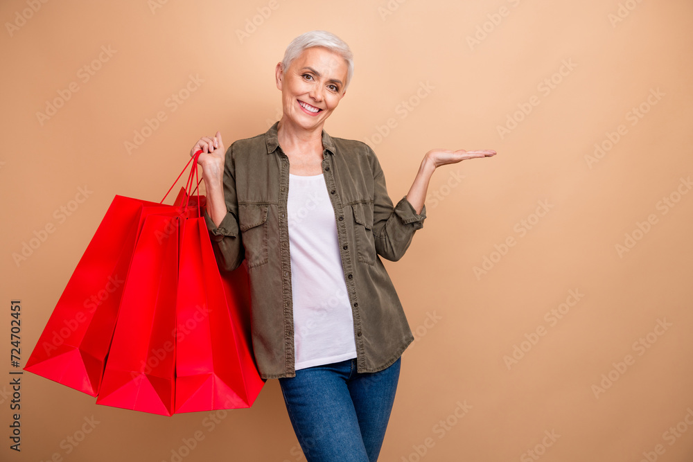 Sticker Photo of blonde short hair business lady enjoy spending money in expensive boutique holding arm brand isolated on beige color background