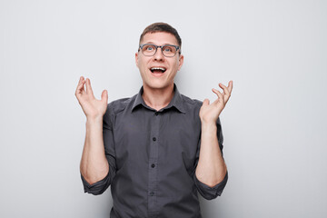 Portrait man happy face smiling joyfully with raised palms and shocked open mouth isolated on white studio background.