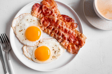 Breakfast with fried eggs, bacon and coffee