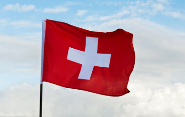 Swiss flag waving against sky