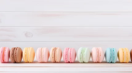 Keuken spatwand met foto Macarons in row on wooden table. Colorful macarons on a table © yLemon