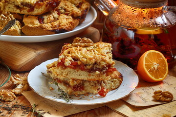 Shortbread cake with jam and tea with lemon on a wooden background