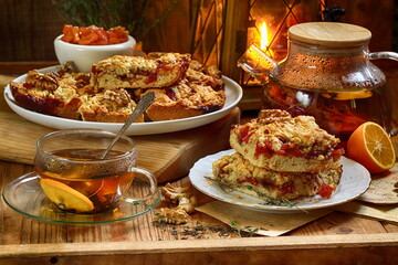 Shortbread cake with jam and tea with lemon on a wooden background
