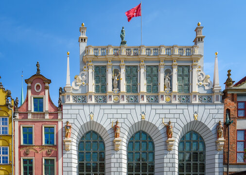 The view of restored 14th century Artus Court, merchant's meeting place in Gdansk old town. Historical town centre on a sunny summer day.
