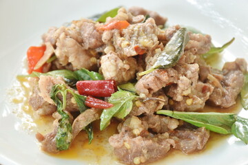 spicy stir fried slice  beef meat with basil leaf and dry chili on plate 