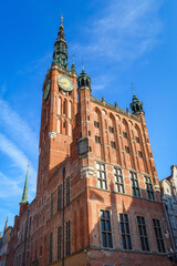 Fototapeta na wymiar Beautiful architecture of the old town in Gdansk with city hall and Artus court, Poland. A walk through the city on a sunny summer day