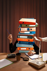 Person at desk with pile of binders instead of body, writing, with hand offering telephone...