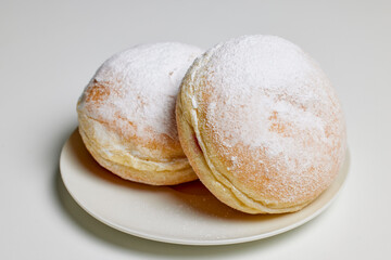 donut filled with fruit jam and powdered sugar on top.