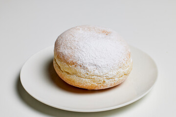 donut filled with fruit jam and powdered sugar on top.