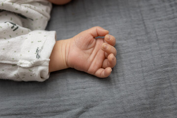 A child's hand on the bed. The concept of nurturing the development and care of a toddler. 