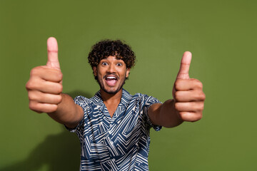 Photo of young overjoyed impressed guy makes like respect you symbols double thumbs up open mouth...