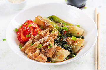 Stir fried of chicken, sweet peppers and bok choy in a bowl on the table. Stir fry pak choi. Asian food.