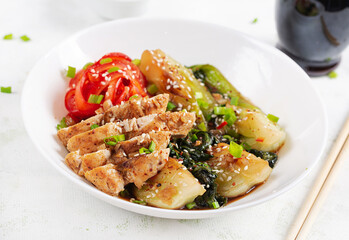 Stir fried of chicken, sweet peppers and bok choy in a bowl on the table. Stir fry pak choi. Asian food.