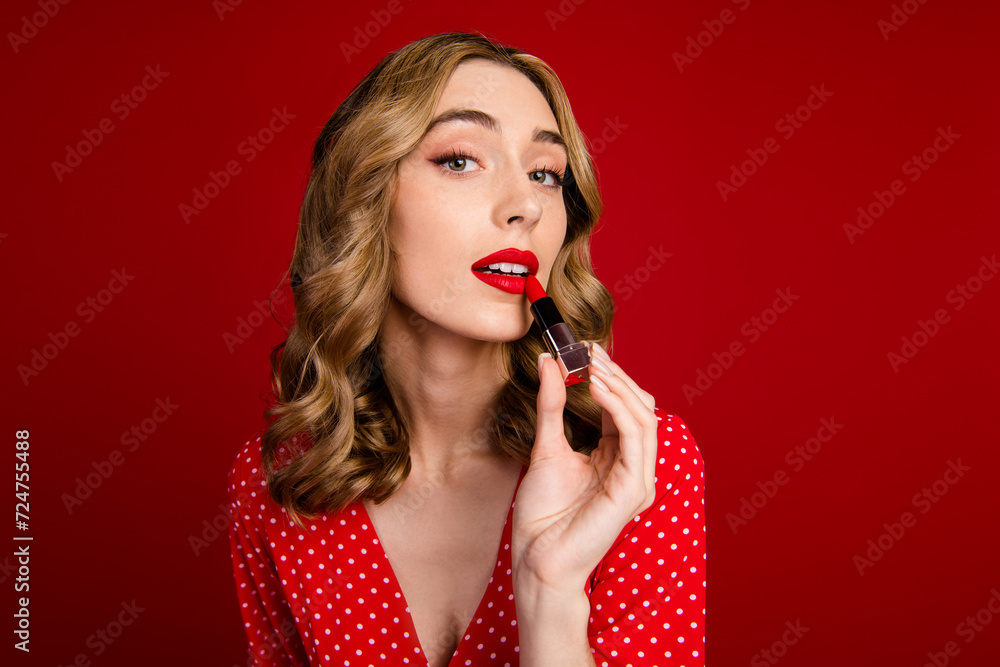 Poster portrait of gorgeous nice person apply lipstick empty space ad offer isolated on red color backgroun