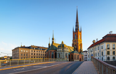 Obraz premium The Riddarholmen Church in Stockholm, Sweden. Cityscape of Stockholm, Sweden. Evening time and soft sunlight. A walk through the city. Panoramic view.