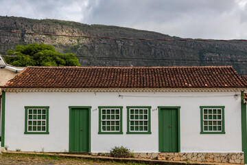 Casa colonial  de janelas e portas verdes e com serra de São José