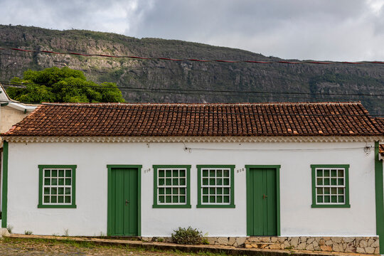 Casa colonial  de janelas e portas verdes e com serra de S&atilde;o Jos&eacute;