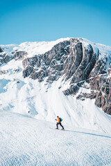 Fototapeta na wymiar A man on ski alpine tour throught snowy Alps in Switzerland or Austria, Backcountry skier in Alps