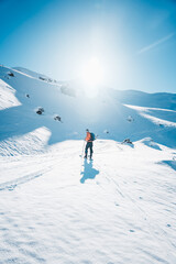 Fototapeta na wymiar A man on ski alpine tour throught snowy Alps in Switzerland or Austria, Backcountry skier in Alps