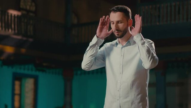 Caucasian Man Starting the Islamic Prayer Alone in an Old Mosque in the Evening