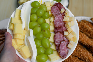 Talerz przekąsek imprezowych ser i wędlina z owocami 