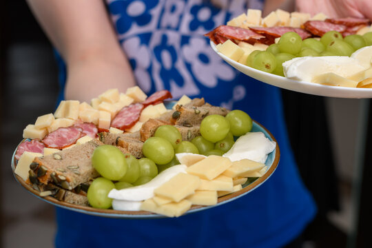Kelnerka trzyma talerze pelne jedzenia, serwuje posiłki 