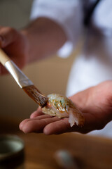 painting a nigiri with sauce