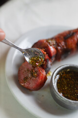 Chimmy Churry argentinan sauce poured in a pork sausage