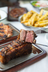 grilled brisket steak on a table garnished by fries