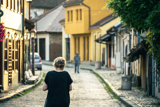 A person walks along an old, historic street