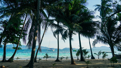 Tropical white sand beach with coco palms and the turquoise sea at Koh Wai Island, Thailand.