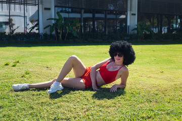 Athletic girl resting lying the grass after physical exercise.