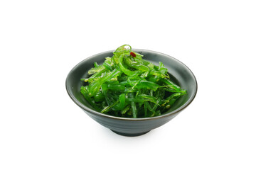 Traditional Japanese wakame seaweed salad with sesame seeds on black bowl isolated on background