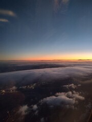 Aerial view at sunset with clouds and sun. Airplane view