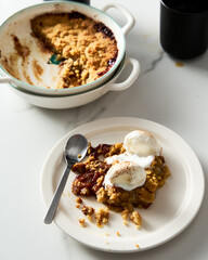 Apple Crumble Pie with vanilla ice cream scoops made from caramelized apples with spices. High-key...