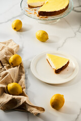 Mascarpone cheesecake with lemon curd and shortbread base. White marble background. High key food photo
