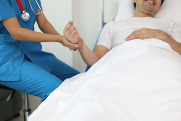 Fototapeta premium Female doctor visits a male patient in the hospital and discusses their illness and treatment progress. Nurses provide treatment for patients in hospitals.
