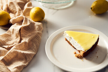 Mascarpone cheesecake with lemon curd and shortbread base. White marble background. High key food...
