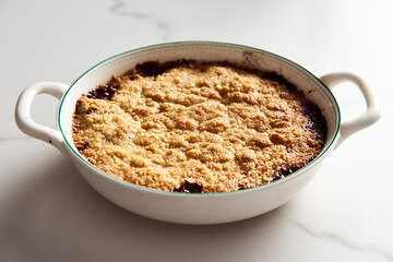 Apple Crumble Pie made from caramelized apples with spices. High-key photo, white marble background. breakfast concept food photo