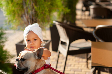 French bulldog on a red leash on a walk with his little girl owner
