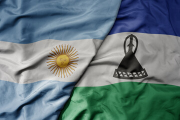 big waving national colorful flag of lesotho and national flag of argentina .