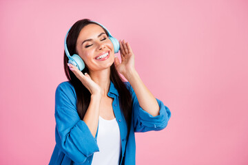 Portrait of relaxed positive woman wear stylish clothes touching headphones enjoy good quality...